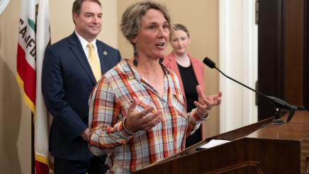 Sarah Keiser, CEO of Wild Oat Hollow, at podium, speaking